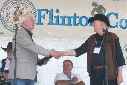 Neville Wells being inducted into the Land O’Lakes Traditional Music Hall of Fame by Don White Saturday at the Flinton Jamboree.